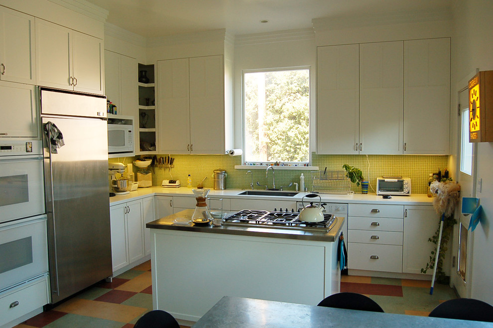 Exempel på ett modernt kök, med en köksö, skåp i shakerstil, vita skåp, bänkskiva i kvarts, grönt stänkskydd, rostfria vitvaror, en enkel diskho och linoleumgolv