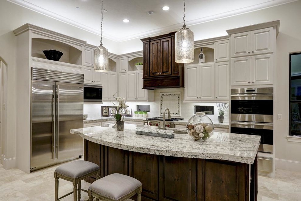 Example of a large tuscan l-shaped travertine floor and beige floor open concept kitchen design in Houston with an undermount sink, raised-panel cabinets, gray cabinets, granite countertops, white backsplash, stone tile backsplash, stainless steel appliances, an island and gray countertops