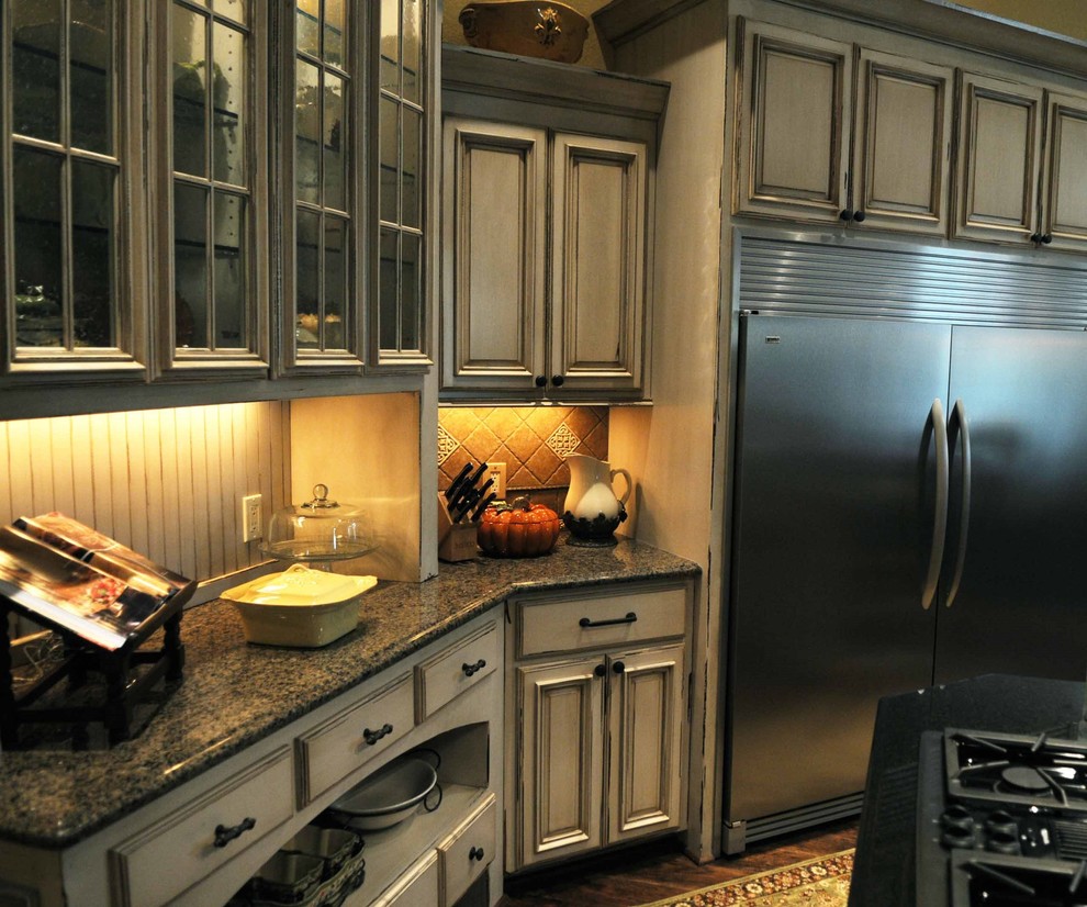 Example of a tuscan kitchen design in Other with recessed-panel cabinets, distressed cabinets and granite countertops