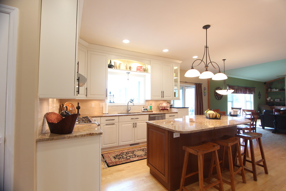 Exempel på ett mellanstort klassiskt kök, med en undermonterad diskho, luckor med upphöjd panel, vita skåp, granitbänkskiva, beige stänkskydd, stänkskydd i stenkakel, rostfria vitvaror, ljust trägolv och en köksö
