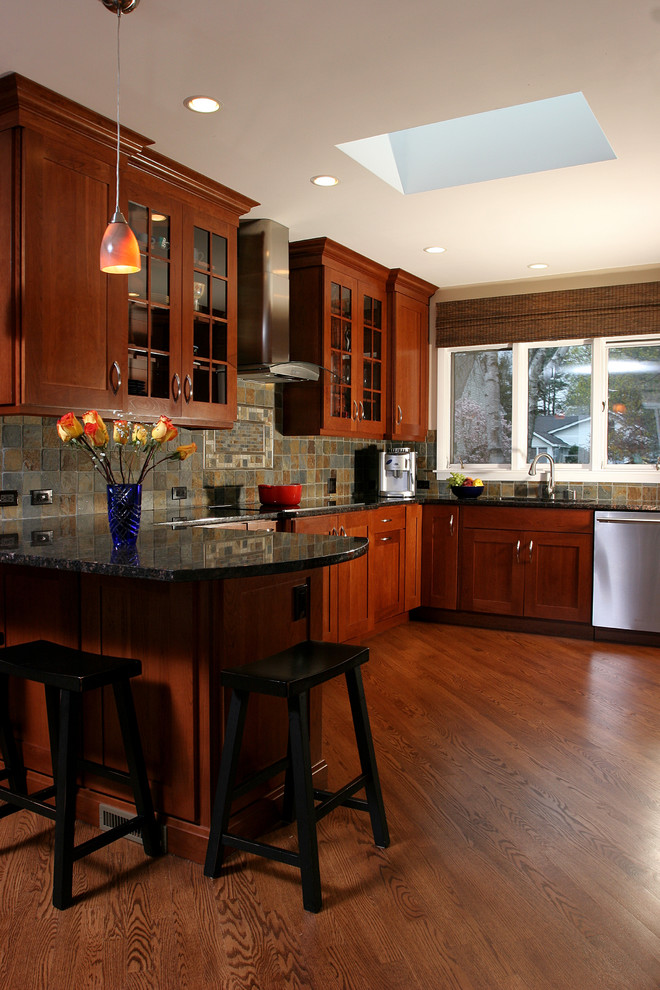 Eat-in kitchen - small transitional u-shaped medium tone wood floor eat-in kitchen idea in Chicago with an undermount sink, shaker cabinets, medium tone wood cabinets, granite countertops, brown backsplash, stone tile backsplash, stainless steel appliances and a peninsula