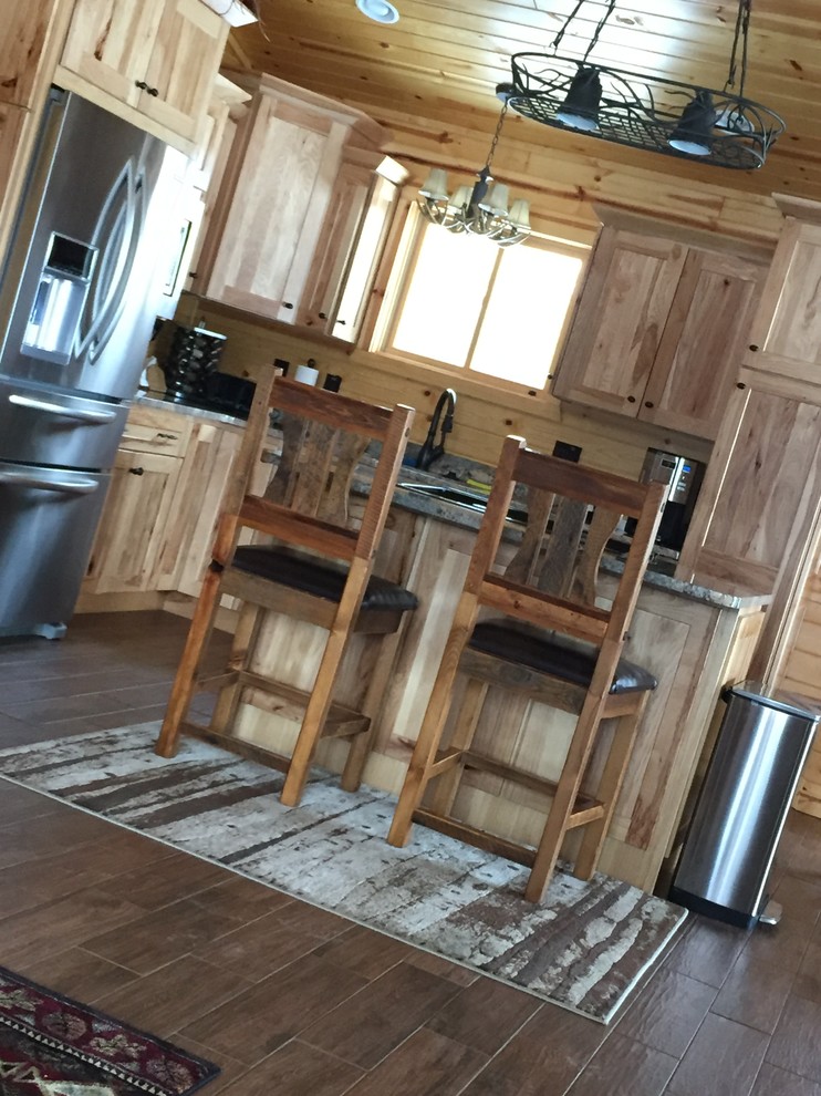 Rustik inredning av ett stort kök, med en dubbel diskho, luckor med lamellpanel, skåp i ljust trä, granitbänkskiva, rostfria vitvaror, skiffergolv, en köksö och flerfärgat golv
