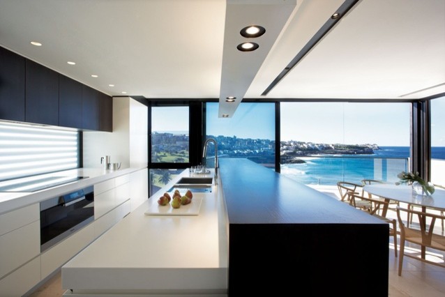 Imagen de cocina comedor lineal actual pequeña con armarios con paneles lisos, puertas de armario blancas y una isla