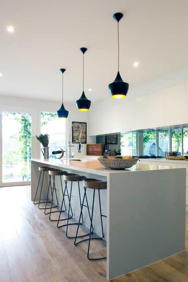 Zweizeilige, Mittelgroße Moderne Küche mit flächenbündigen Schrankfronten, Rückwand aus Glasfliesen und Kücheninsel in Melbourne