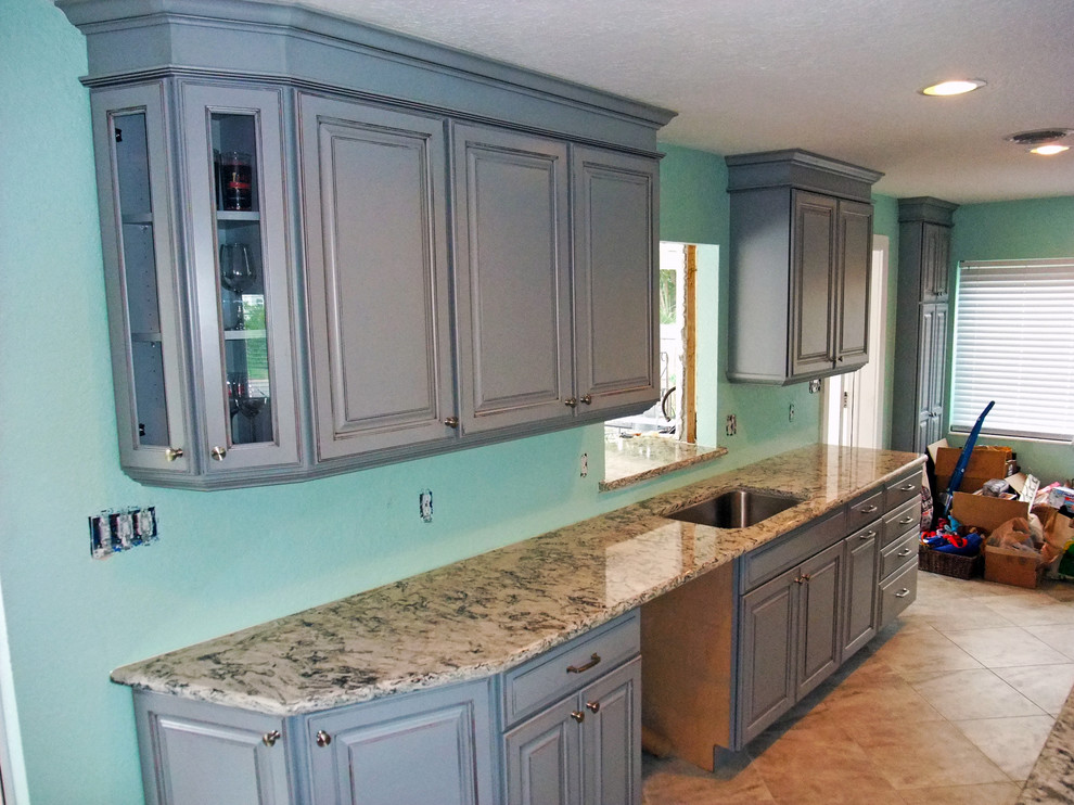 Photo of a medium sized coastal galley kitchen in Orlando with a submerged sink, raised-panel cabinets, engineered stone countertops, stainless steel appliances and no island.