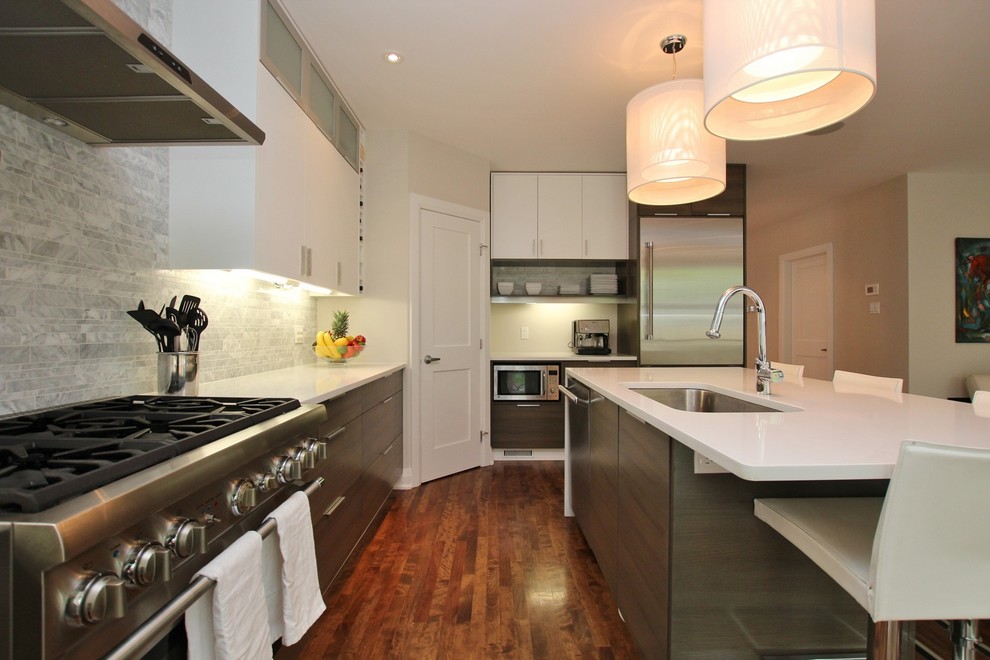 Inspiration for a mid-sized contemporary u-shaped medium tone wood floor and brown floor eat-in kitchen remodel in Ottawa with an undermount sink, flat-panel cabinets, gray cabinets, gray backsplash, ceramic backsplash, stainless steel appliances, an island, quartz countertops and white countertops