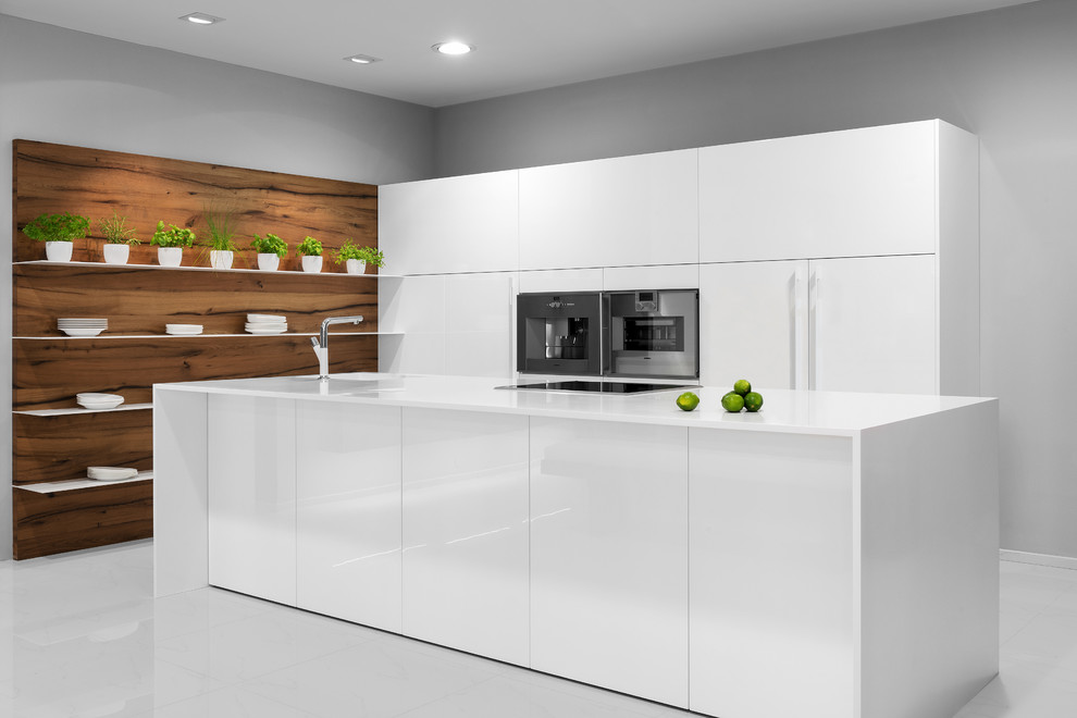 Imagen de cocina comedor minimalista grande con electrodomésticos de acero inoxidable, dos o más islas, armarios con paneles lisos y puertas de armario blancas