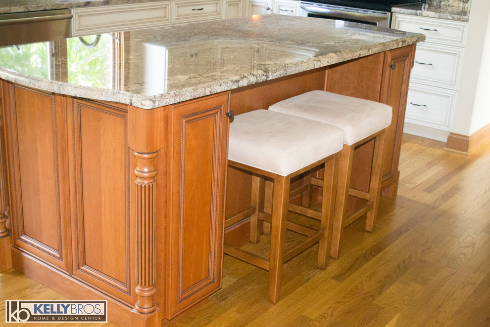 Immagine di una cucina tradizionale con lavello sottopiano, top in granito, elettrodomestici in acciaio inossidabile e pavimento in legno massello medio