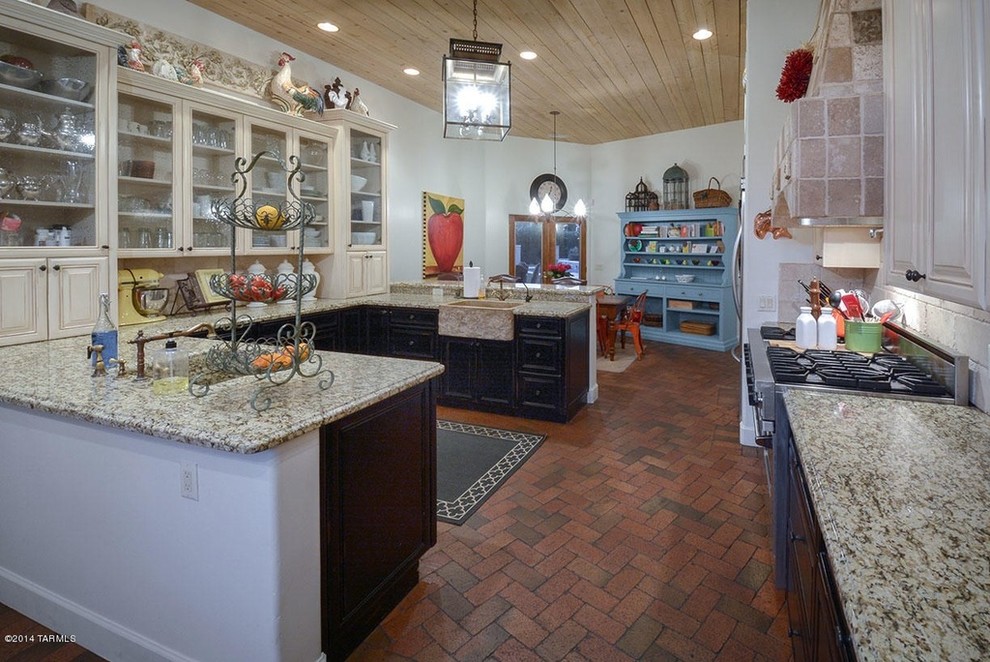 Large country u-shaped brick floor eat-in kitchen photo in Phoenix with a farmhouse sink, recessed-panel cabinets, black cabinets, granite countertops and no island