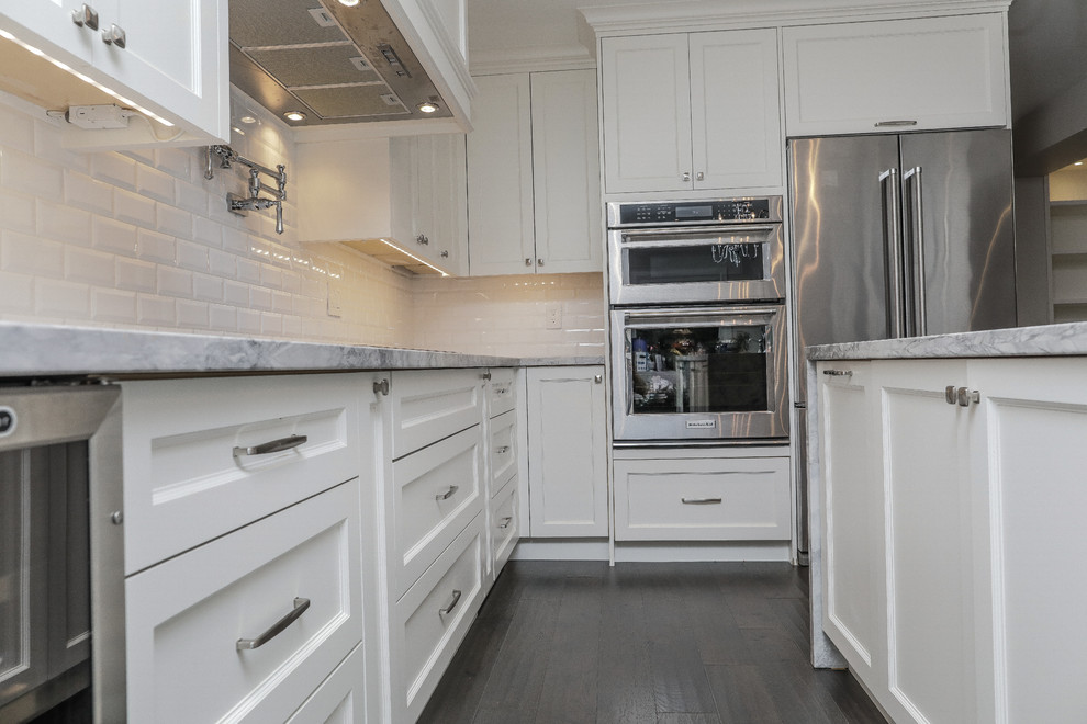 Idéer för att renovera ett mellanstort vintage grå grått kök, med en undermonterad diskho, skåp i shakerstil, vita skåp, granitbänkskiva, vitt stänkskydd, stänkskydd i tunnelbanekakel, rostfria vitvaror, mörkt trägolv, en köksö och grått golv