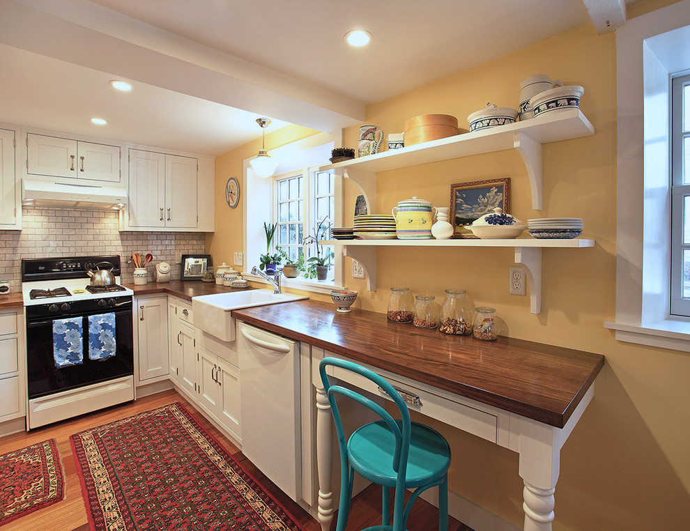 Modelo de cocina clásica con fregadero encastrado, armarios abiertos, encimera de madera, salpicadero blanco, salpicadero de azulejos tipo metro y electrodomésticos blancos
