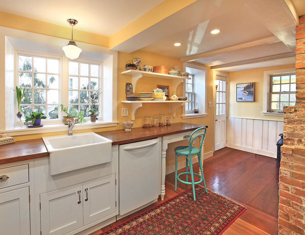 Inspiration for a timeless kitchen remodel in Boston with a farmhouse sink, wood countertops, white appliances, beaded inset cabinets and white cabinets