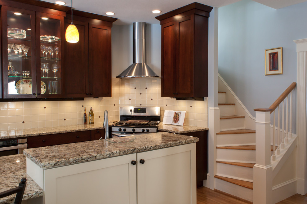 Example of a mid-sized classic l-shaped medium tone wood floor eat-in kitchen design in Boston with an undermount sink, recessed-panel cabinets, dark wood cabinets, granite countertops, beige backsplash, ceramic backsplash and stainless steel appliances