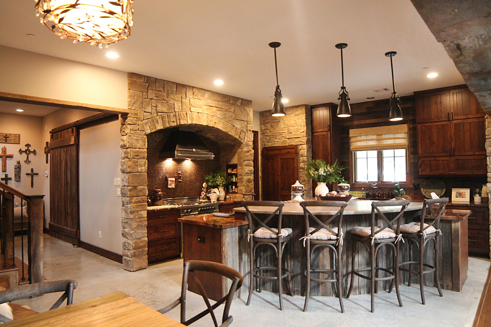 Foto de cocinas en L de estilo de casa de campo grande abierta con fregadero bajoencimera, armarios estilo shaker, puertas de armario con efecto envejecido, encimera de mármol, salpicadero marrón, salpicadero con mosaicos de azulejos, electrodomésticos de acero inoxidable, suelo de cemento y una isla