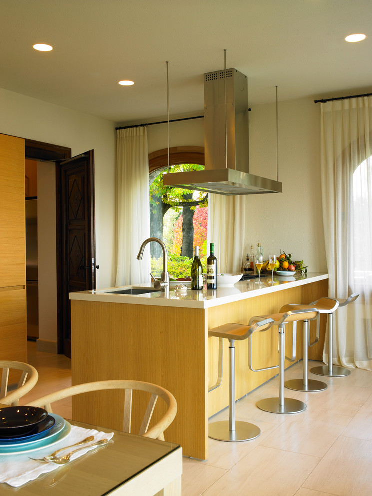 Источник вдохновения для домашнего уюта: кухня среднего размера в стиле модернизм с светлыми деревянными фасадами, полуостровом, обеденным столом, врезной мойкой и столешницей из акрилового камня