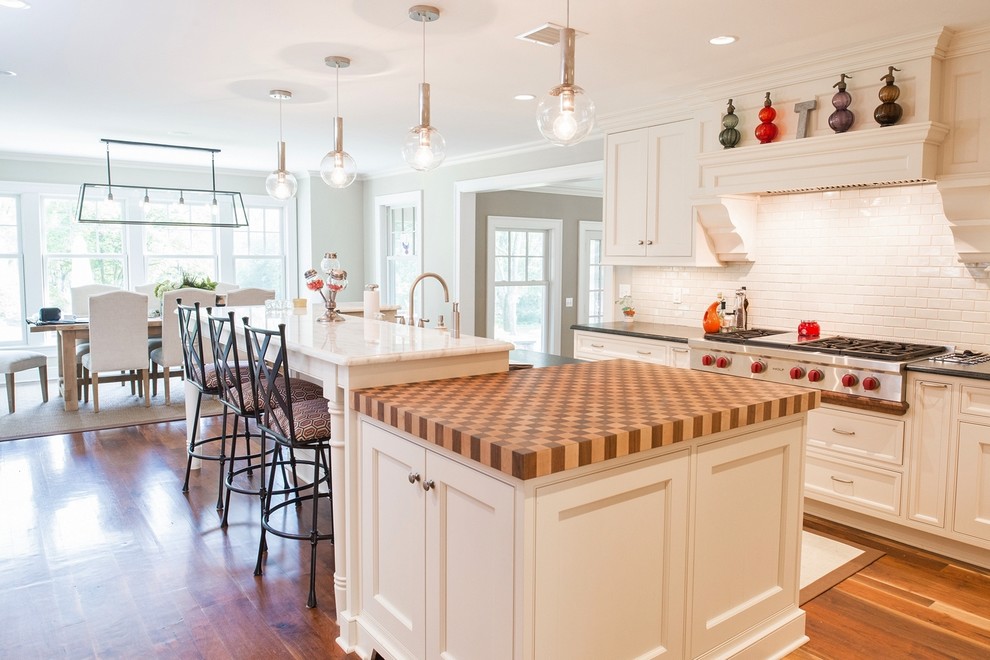 Exempel på ett stort klassiskt kök, med en rustik diskho, luckor med infälld panel, vita skåp, marmorbänkskiva, vitt stänkskydd, stänkskydd i keramik, rostfria vitvaror, mellanmörkt trägolv och en köksö