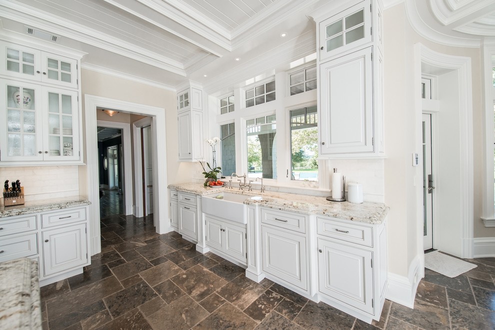 Open concept kitchen - huge traditional u-shaped porcelain tile open concept kitchen idea in New York with a farmhouse sink, white cabinets, granite countertops, white backsplash, stainless steel appliances and an island