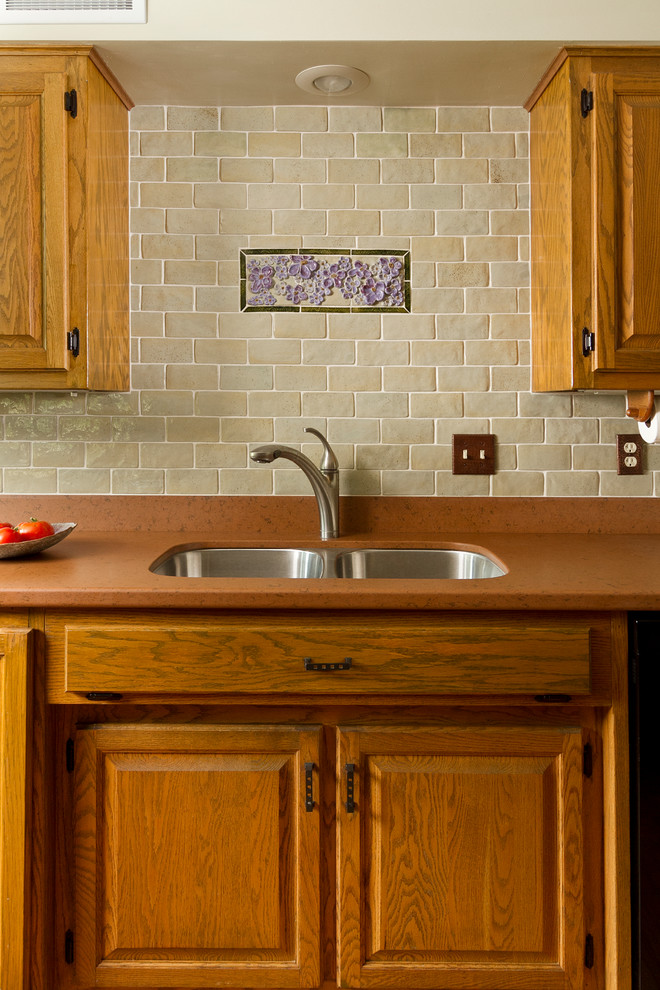 Inredning av ett modernt mellanstort kök, med luckor med upphöjd panel, skåp i mellenmörkt trä, grönt stänkskydd, stänkskydd i keramik, svarta vitvaror, mellanmörkt trägolv och en köksö