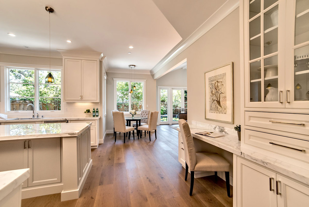 Example of a mid-sized classic medium tone wood floor eat-in kitchen design in San Francisco with a single-bowl sink, shaker cabinets, white cabinets, marble countertops, white backsplash, subway tile backsplash, stainless steel appliances and an island