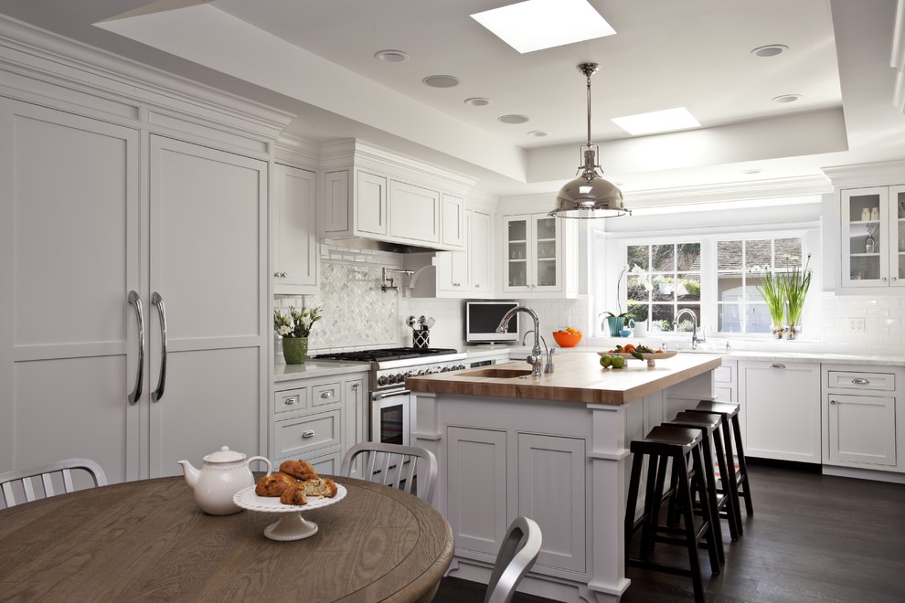 Open concept kitchen - large traditional u-shaped dark wood floor open concept kitchen idea in San Francisco with an undermount sink, beaded inset cabinets, white cabinets, marble countertops, white backsplash, subway tile backsplash, paneled appliances and an island