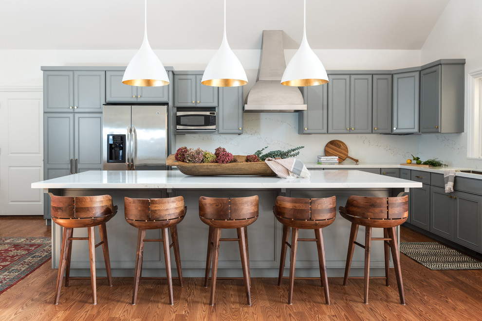 Klassische Küche in L-Form mit Schrankfronten mit vertiefter Füllung, grauen Schränken, Küchenrückwand in Weiß, Küchengeräten aus Edelstahl, braunem Holzboden, Kücheninsel und braunem Boden in San Francisco