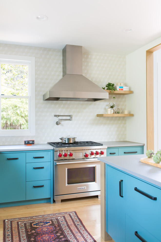 Design ideas for a medium sized midcentury l-shaped kitchen/diner in San Francisco with flat-panel cabinets, turquoise cabinets, white splashback, an island, ceramic splashback, stainless steel appliances and light hardwood flooring.