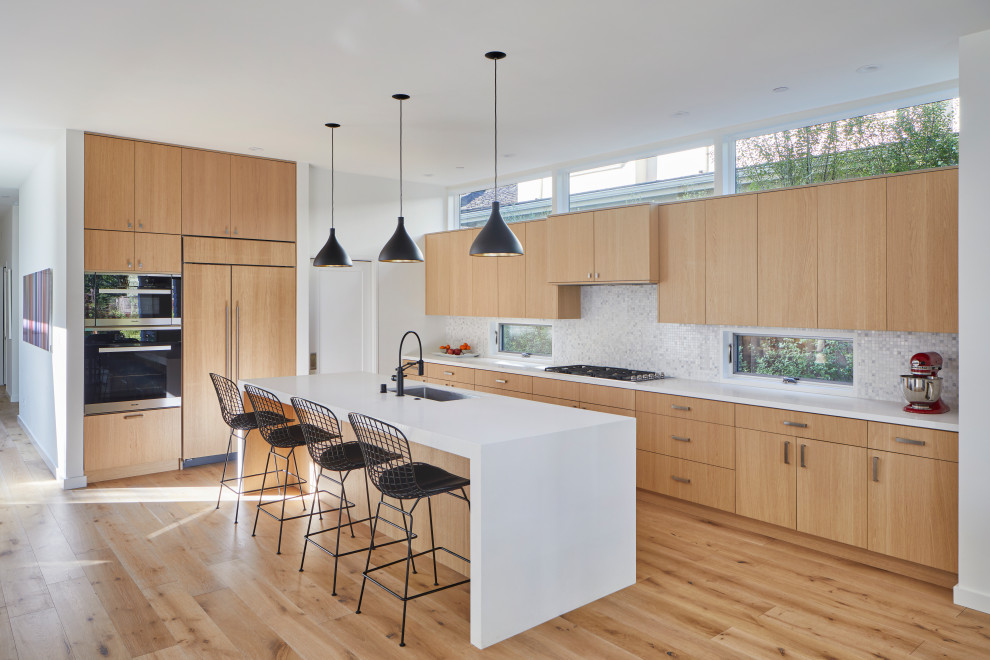 Inspiration for a contemporary l-shaped medium tone wood floor and brown floor kitchen remodel in San Francisco with an undermount sink, beaded inset cabinets, medium tone wood cabinets, white backsplash, mosaic tile backsplash, paneled appliances and white countertops