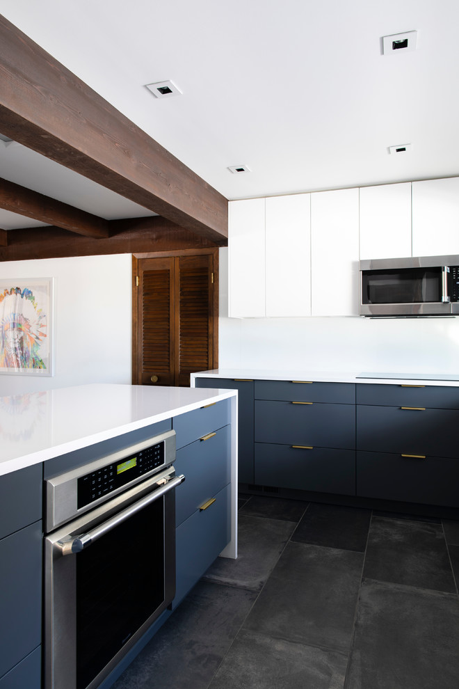 Bild på ett litet retro vit vitt kök, med en undermonterad diskho, släta luckor, grå skåp, bänkskiva i kvartsit, vitt stänkskydd, glaspanel som stänkskydd, integrerade vitvaror, klinkergolv i porslin, en halv köksö och svart golv
