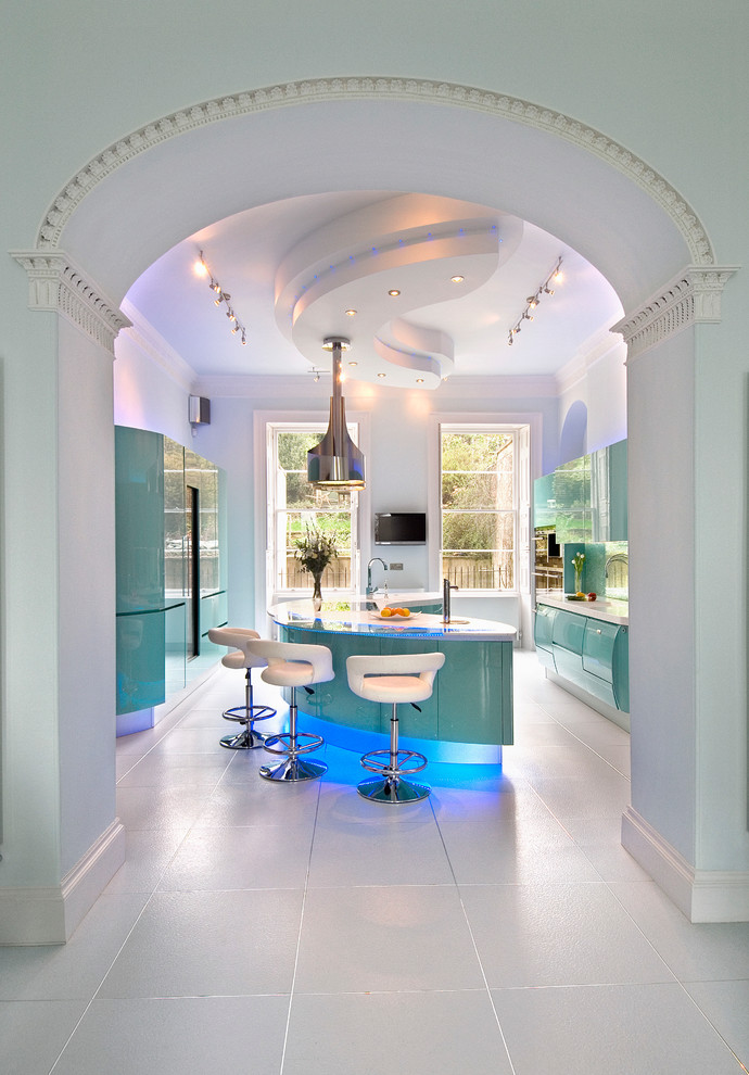 Photo of a large contemporary galley enclosed kitchen in London with an integrated sink, flat-panel cabinets, composite countertops, green splashback, glass sheet splashback, stainless steel appliances, ceramic flooring, an island and blue cabinets.