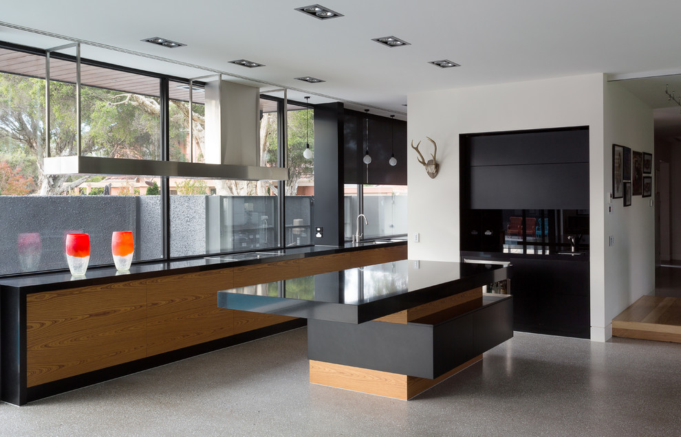 Immagine di una grande cucina contemporanea con paraspruzzi nero e paraspruzzi con lastra di vetro