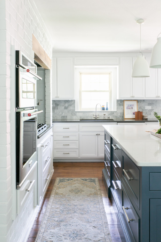 Exempel på ett avskilt, mellanstort modernt vit vitt l-kök, med en undermonterad diskho, skåp i shakerstil, blå skåp, bänkskiva i kvarts, vitt stänkskydd, rostfria vitvaror, mörkt trägolv, en köksö och brunt golv