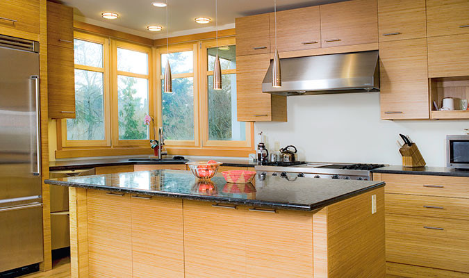 Foto de cocina actual de tamaño medio con armarios con paneles lisos, puertas de armario de madera clara, encimera de cuarzo compacto y una isla