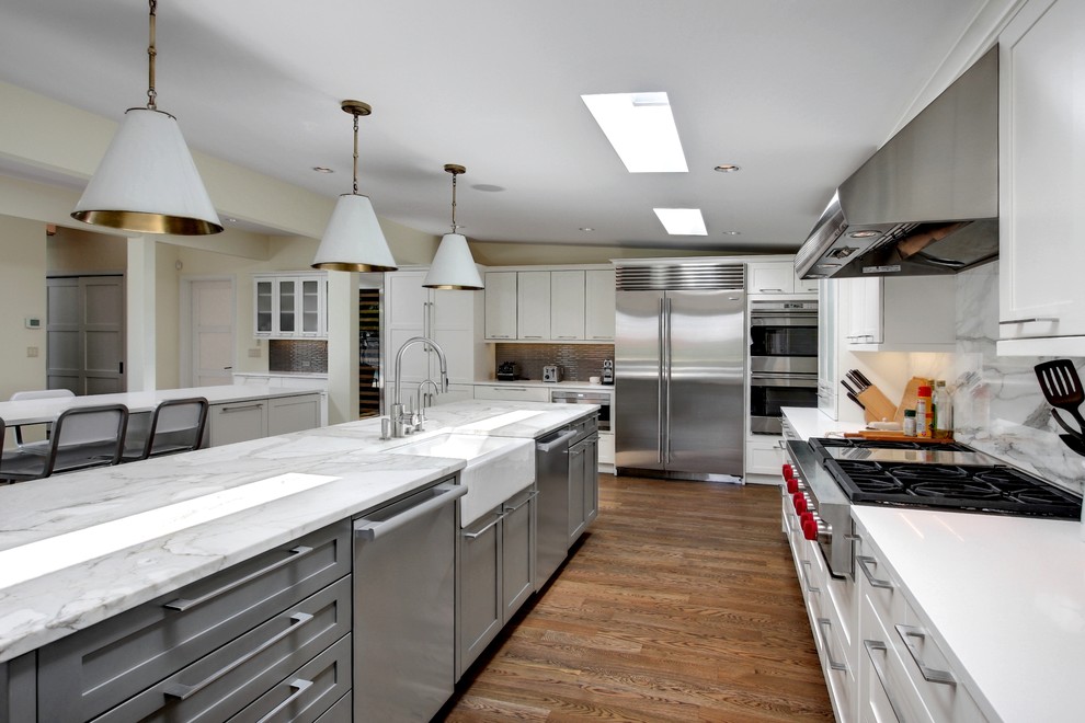 Modern inredning av ett kök och matrum, med en rustik diskho, luckor med infälld panel, vita skåp, marmorbänkskiva, flerfärgad stänkskydd, stänkskydd i stenkakel och rostfria vitvaror