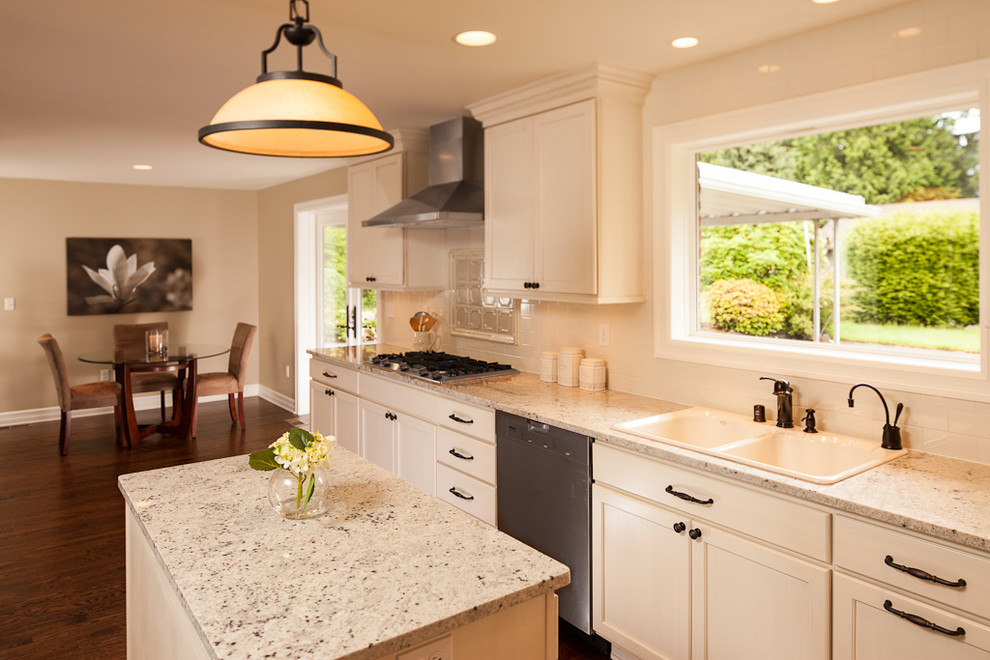 This is an example of a medium sized contemporary galley kitchen in Seattle with a submerged sink, shaker cabinets, white cabinets, stainless steel appliances, medium hardwood flooring and an island.