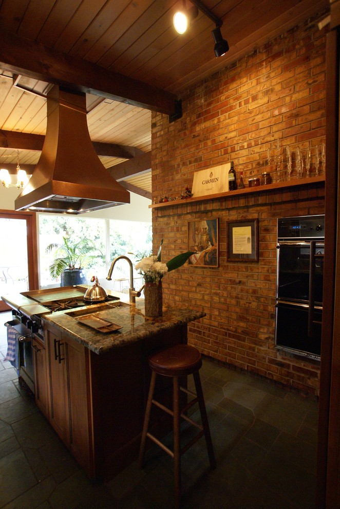 Exempel på ett mellanstort eklektiskt kök, med släta luckor, skåp i slitet trä, granitbänkskiva, stänkskydd i sten, integrerade vitvaror, skiffergolv och en köksö