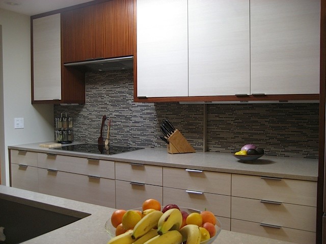 Bild på ett mellanstort retro kök, med en undermonterad diskho, släta luckor, vita skåp, bänkskiva i kvarts, stänkskydd i stickkakel, rostfria vitvaror, ljust trägolv och en köksö