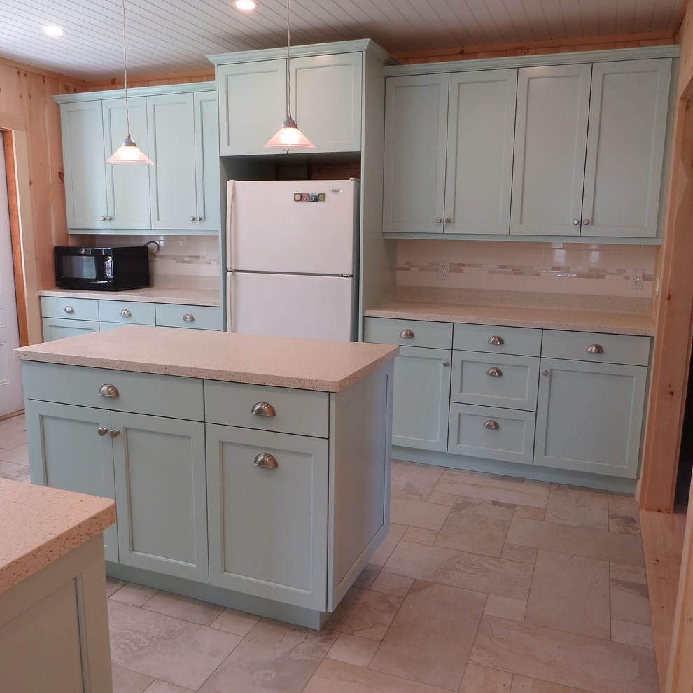 Inspiration for a mid-sized coastal galley porcelain tile and multicolored floor enclosed kitchen remodel in Portland Maine with an undermount sink, recessed-panel cabinets, blue cabinets, solid surface countertops, white backsplash, subway tile backsplash, stainless steel appliances and an island