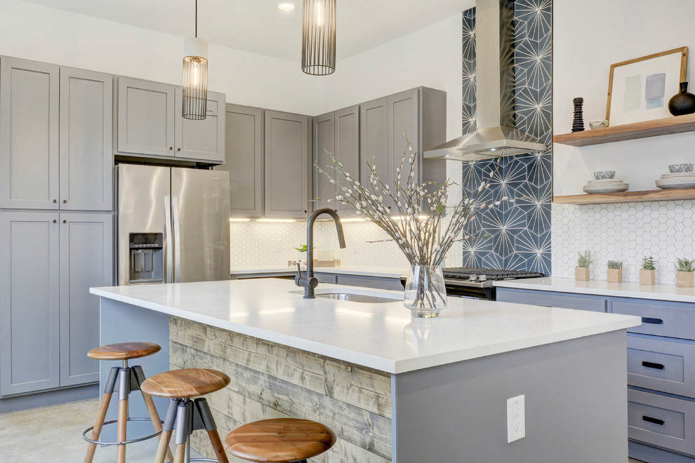 Diseño de cocinas en U clásico renovado, cerrado, con fregadero bajoencimera, armarios estilo shaker, puertas de armario grises, salpicadero blanco, electrodomésticos de acero inoxidable, una isla y suelo beige