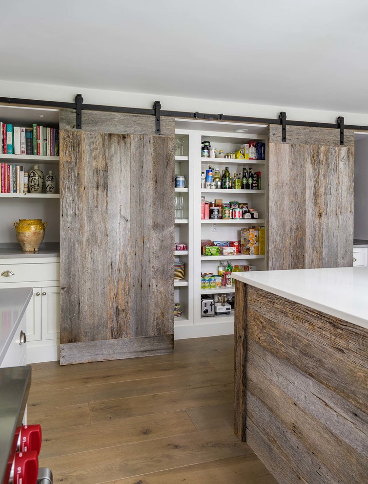 Inspiration for a mid-sized cottage light wood floor and brown floor kitchen remodel in Boston with recessed-panel cabinets, white cabinets, quartzite countertops, stainless steel appliances and an island