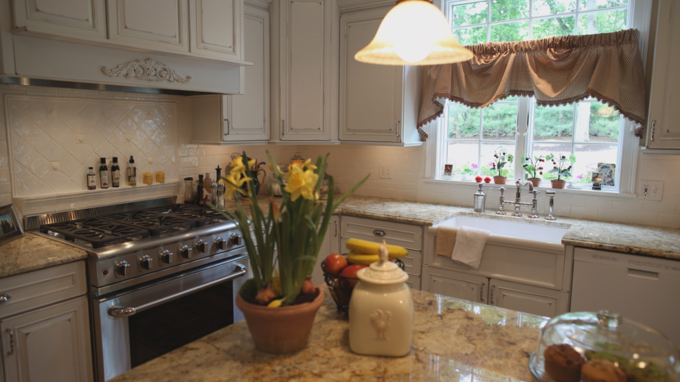 Klassische Küche mit Landhausspüle, profilierten Schrankfronten, Schränken im Used-Look, Granit-Arbeitsplatte, Küchenrückwand in Weiß, Rückwand aus Keramikfliesen, weißen Elektrogeräten, braunem Holzboden und Kücheninsel in Providence