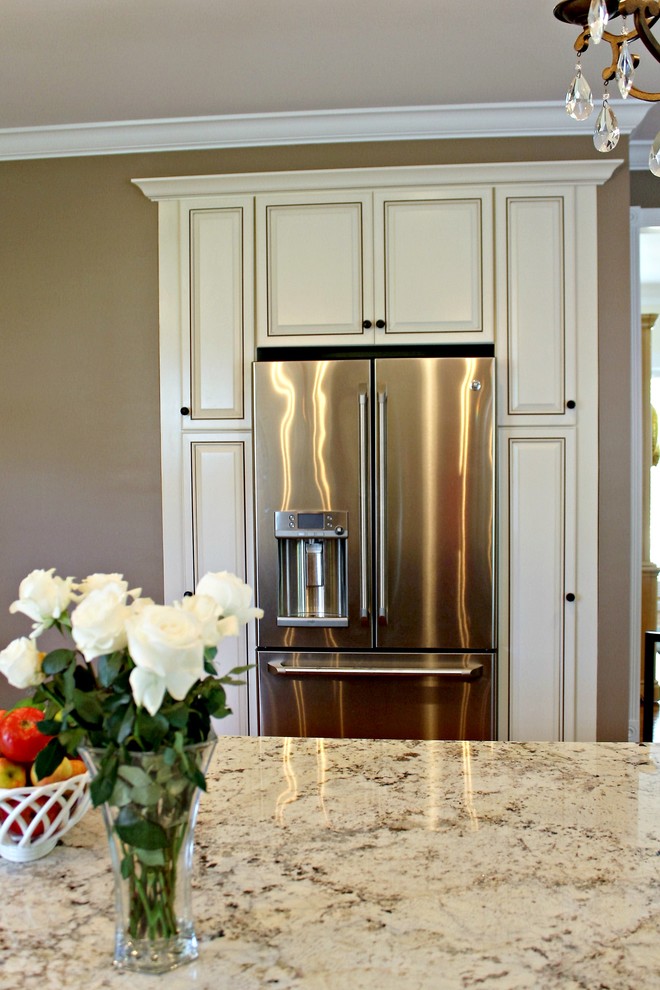 Exempel på ett stort klassiskt kök, med en undermonterad diskho, luckor med upphöjd panel, beige skåp, granitbänkskiva, beige stänkskydd, stänkskydd i stenkakel, rostfria vitvaror, mellanmörkt trägolv och en köksö