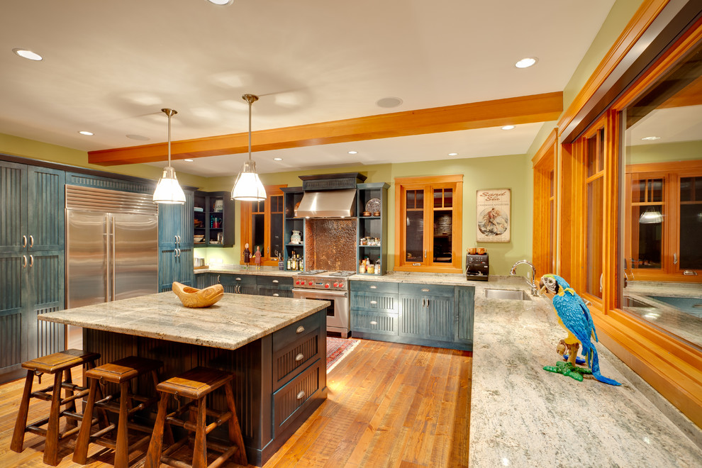 Eat-in kitchen - traditional u-shaped light wood floor and orange floor eat-in kitchen idea in Vancouver with a drop-in sink, shaker cabinets, blue cabinets, granite countertops, stainless steel appliances, an island and beige countertops