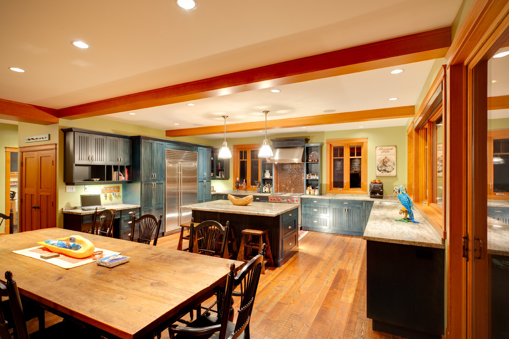 Klassische Wohnküche in U-Form mit Einbauwaschbecken, Schrankfronten im Shaker-Stil, blauen Schränken, Granit-Arbeitsplatte, Küchengeräten aus Edelstahl, hellem Holzboden, Kücheninsel, orangem Boden und beiger Arbeitsplatte in Vancouver