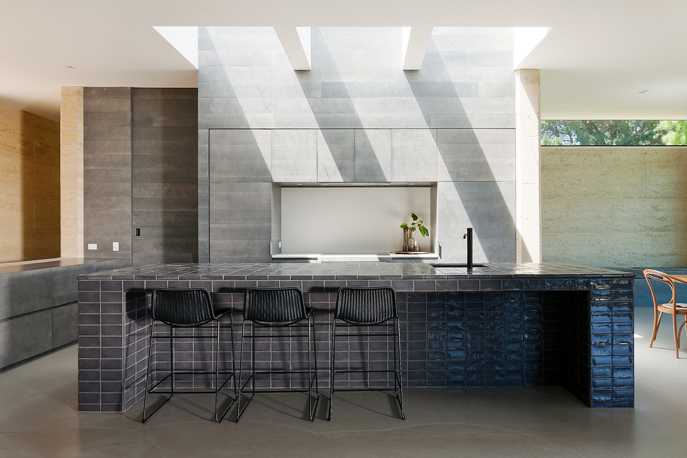 Photo of a modern l-shaped kitchen/diner in Melbourne with a submerged sink, flat-panel cabinets, grey cabinets, grey splashback, integrated appliances and an island.