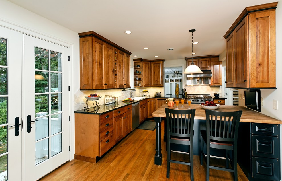 На фото: кухня в классическом стиле с фасадами цвета дерева среднего тона и техникой из нержавеющей стали