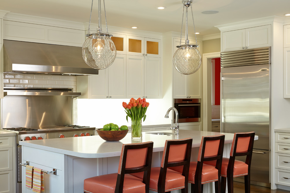 Enclosed kitchen - mid-sized transitional l-shaped dark wood floor and brown floor enclosed kitchen idea in San Francisco with an island, an undermount sink, shaker cabinets, white cabinets, quartz countertops, white backsplash, stainless steel appliances and subway tile backsplash