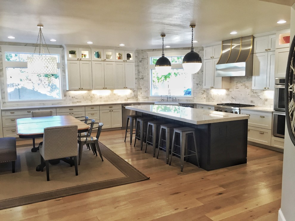 フェニックスにある高級な広いトランジショナルスタイルのおしゃれなキッチン (エプロンフロントシンク、シェーカースタイル扉のキャビネット、白いキャビネット、クオーツストーンカウンター、白いキッチンパネル、大理石のキッチンパネル、シルバーの調理設備、ラミネートの床、ベージュの床、白いキッチンカウンター) の写真