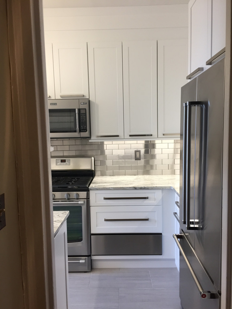 Foto på ett kök och matrum, med skåp i shakerstil, vita skåp, stänkskydd med metallisk yta, stänkskydd i metallkakel och rostfria vitvaror