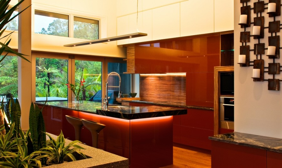 Immagine di una grande cucina moderna con paraspruzzi multicolore, paraspruzzi con lastra di vetro, elettrodomestici neri, lavello sottopiano, ante lisce, ante rosse, top in granito e parquet chiaro