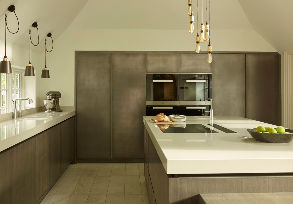Immagine di un cucina con isola centrale design con lavello sottopiano, ante lisce e ante marroni